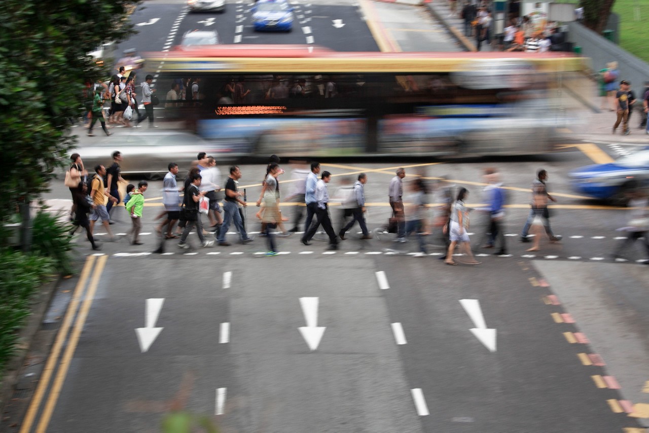 Commuters cross a street in Singapore.
